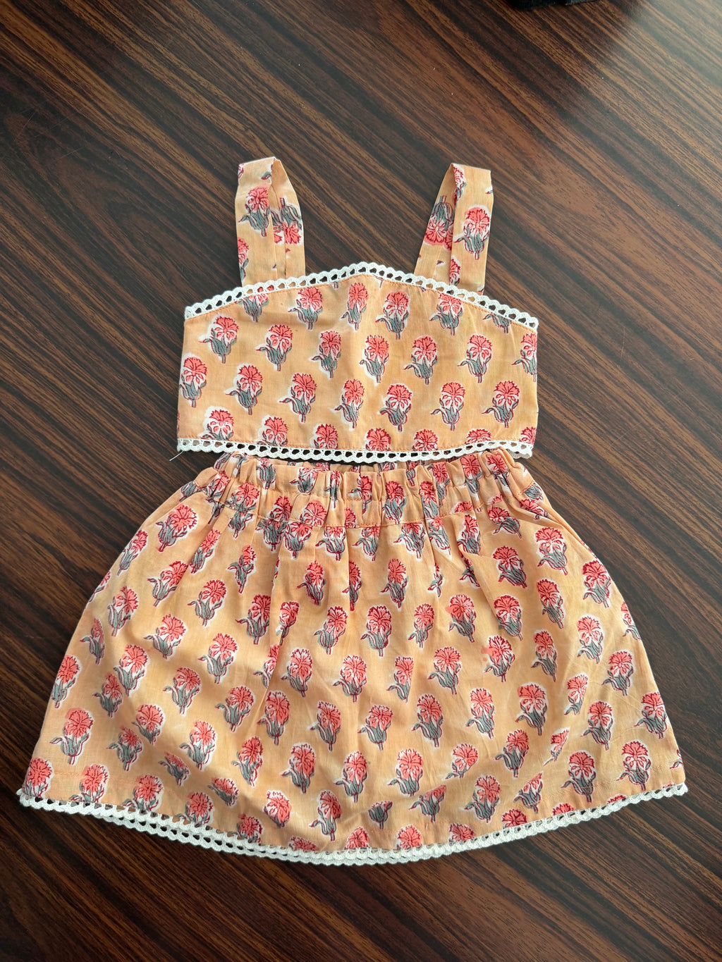 Fabric dress with floral pattern on a wooden surface