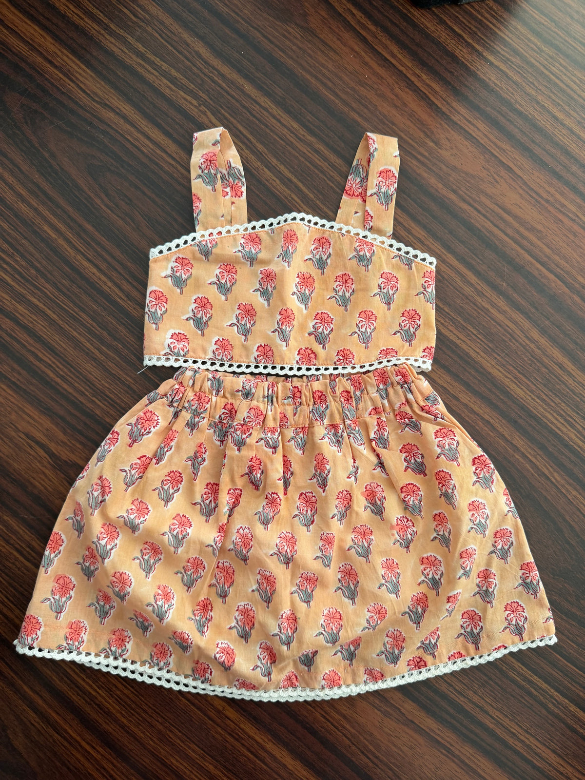 Fabric dress with floral pattern on a wooden surface