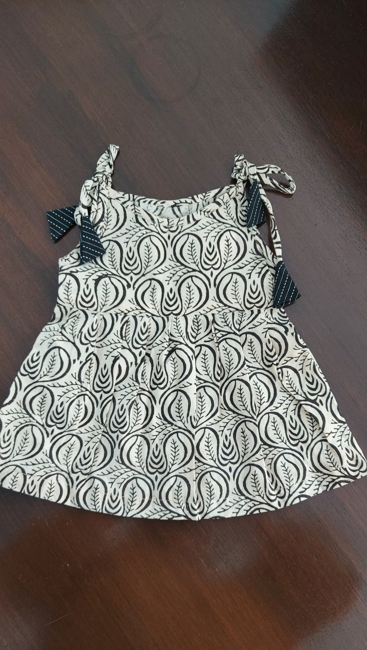 Black and white patterned dress on a wooden surface