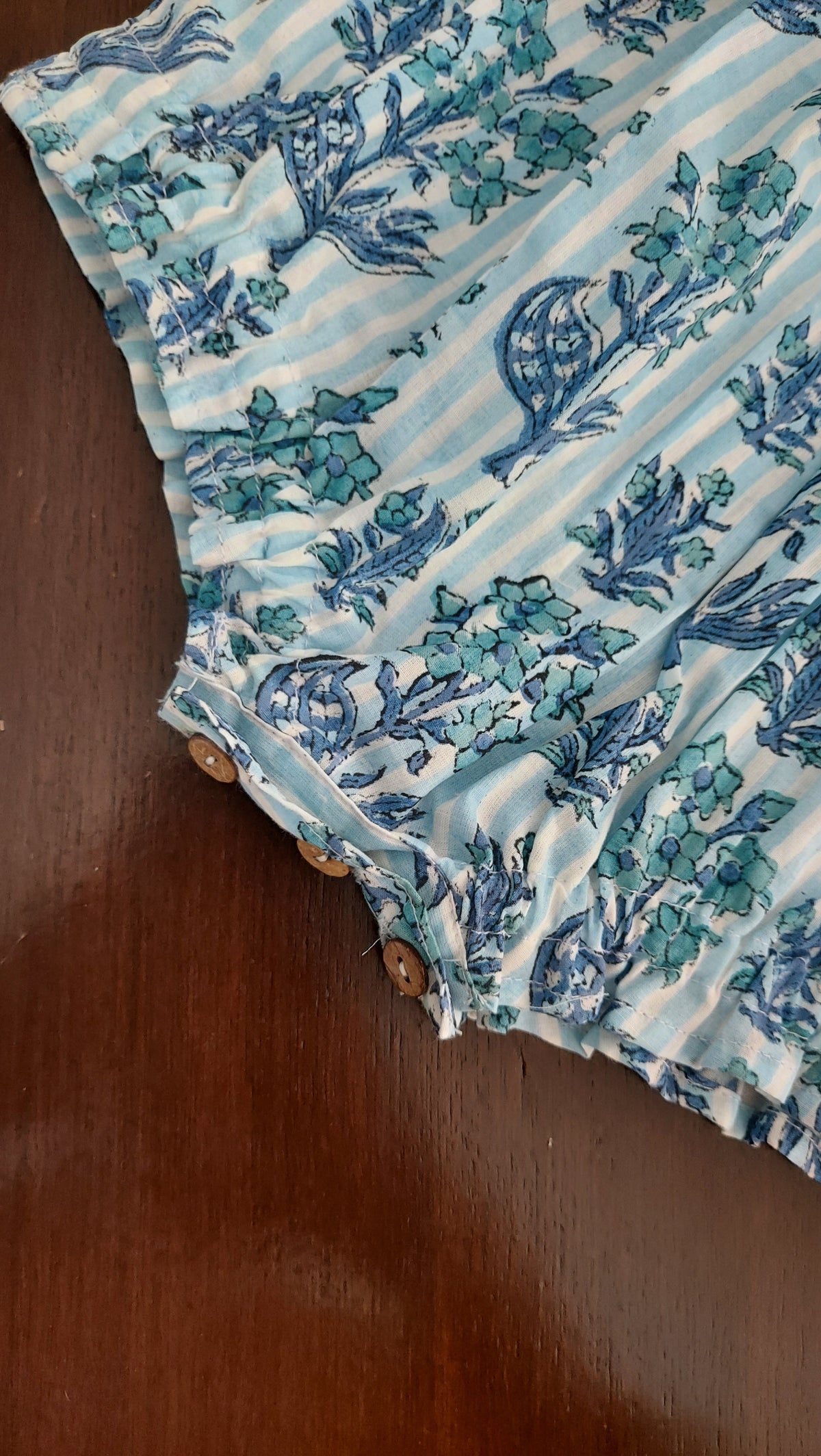 Fabric with blue floral pattern on a wooden surface