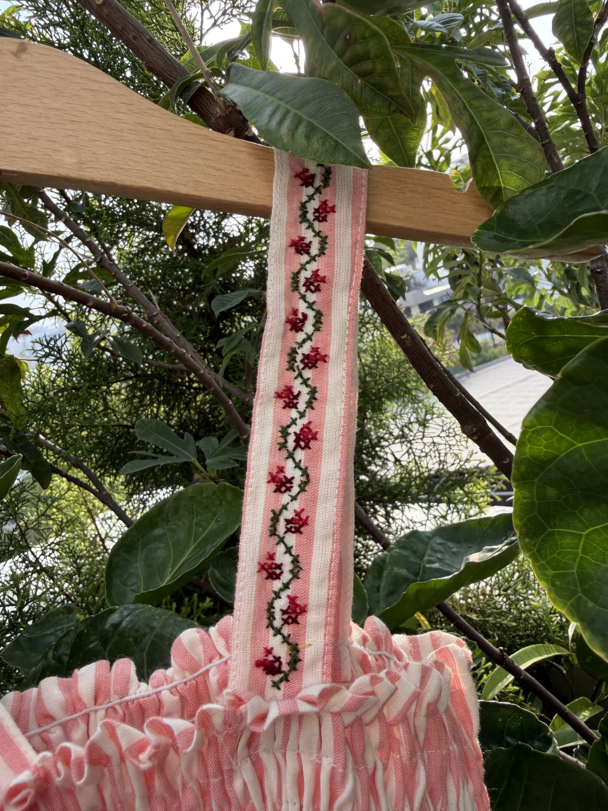 Decorative ribbon with floral pattern on a wooden stick against a natural background