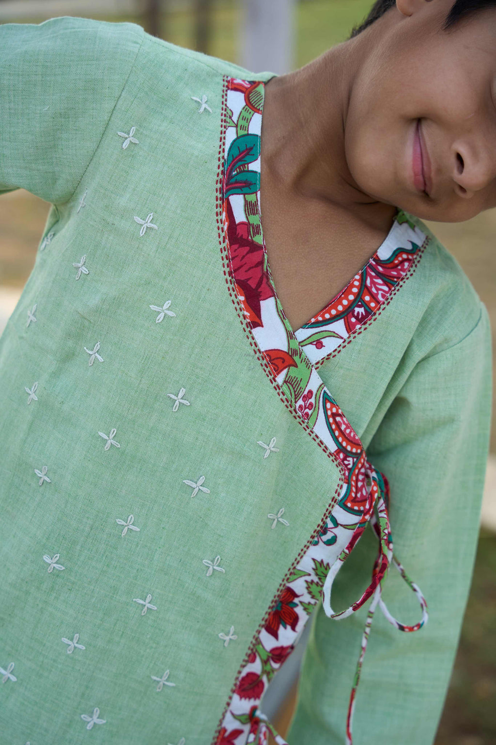 Close-up of a green garment with a colorful neckline