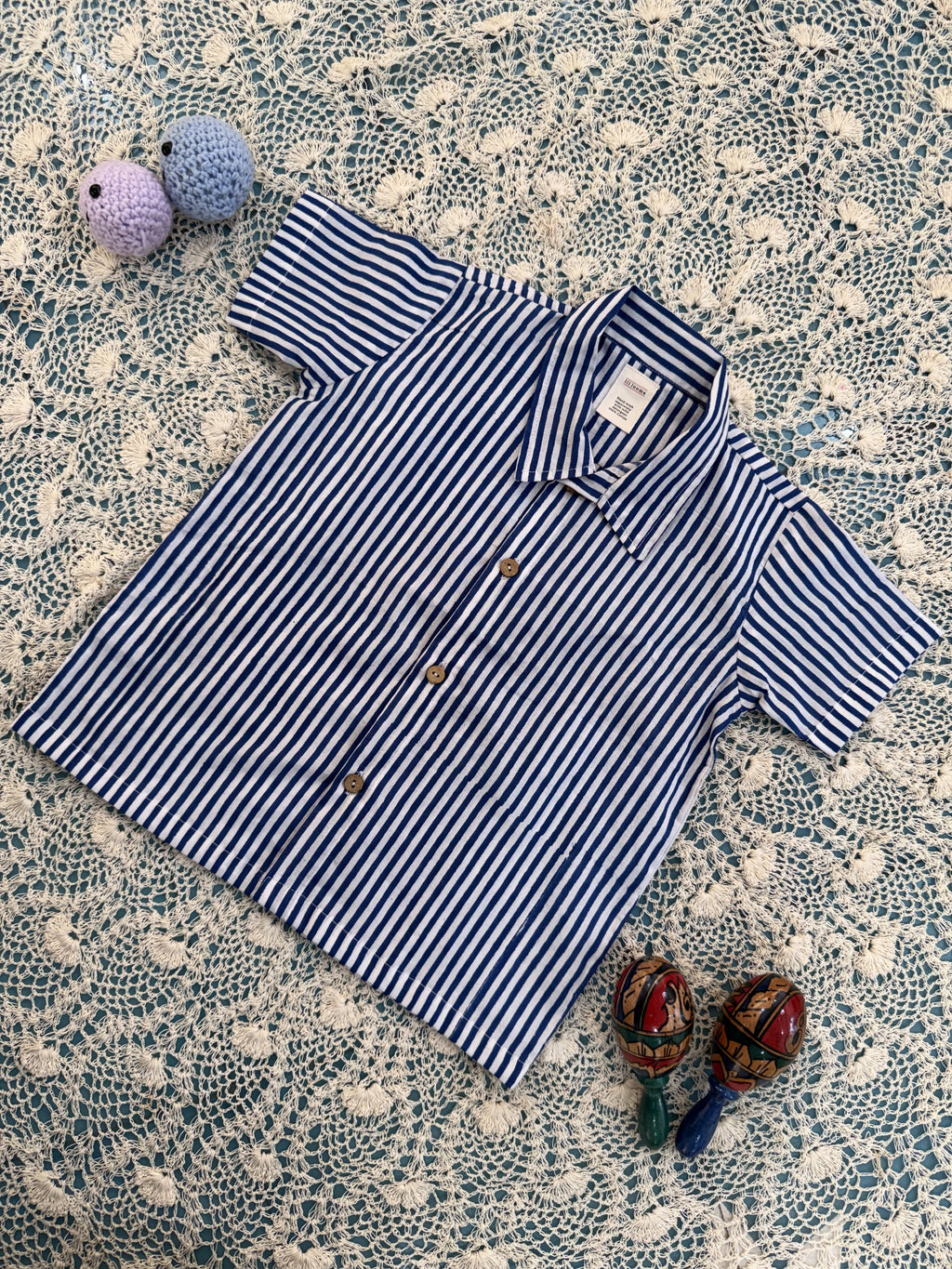 Striped shirt on a textured surface with decorative items