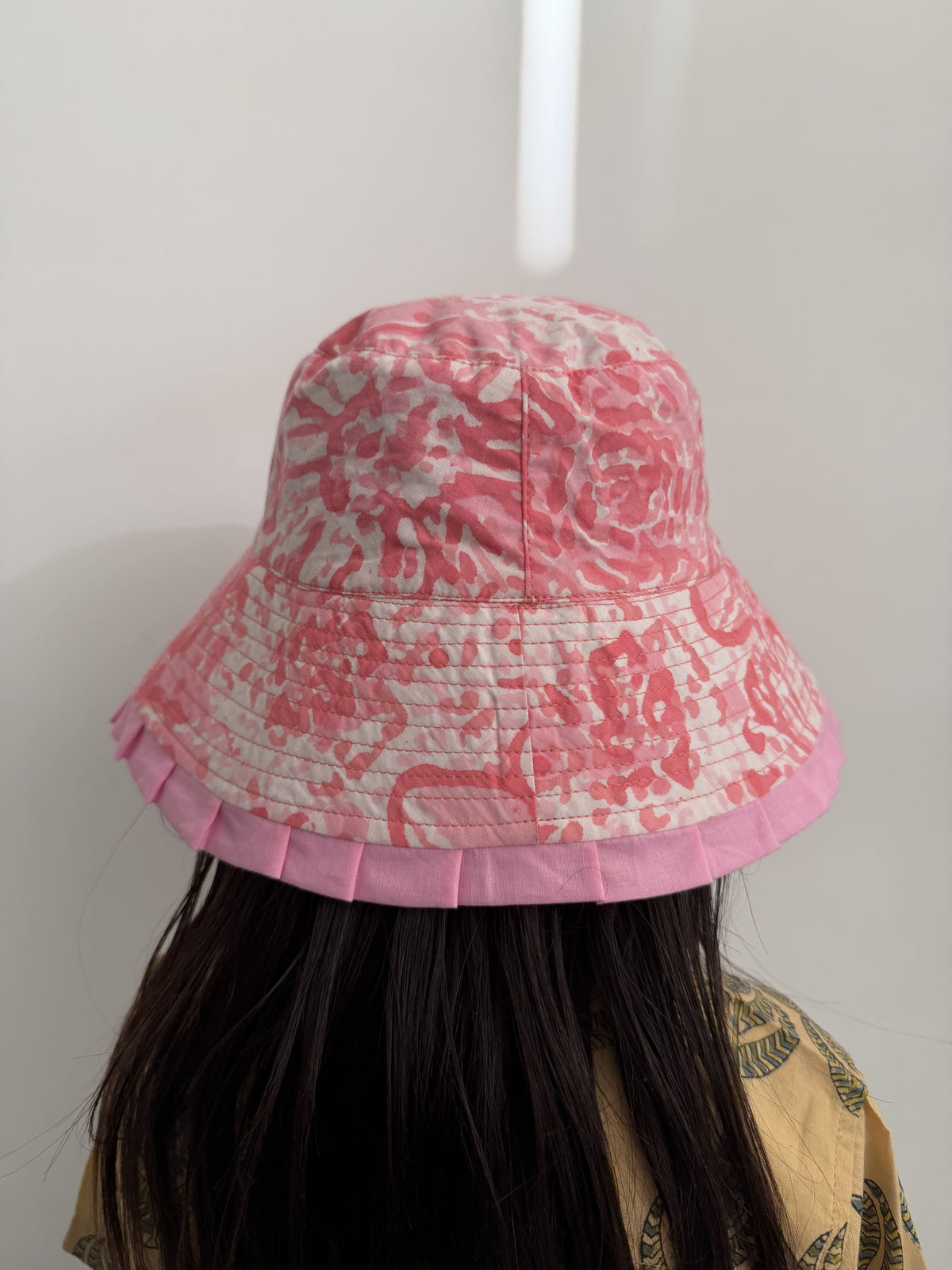 Pink patterned hair bun maker on a white background