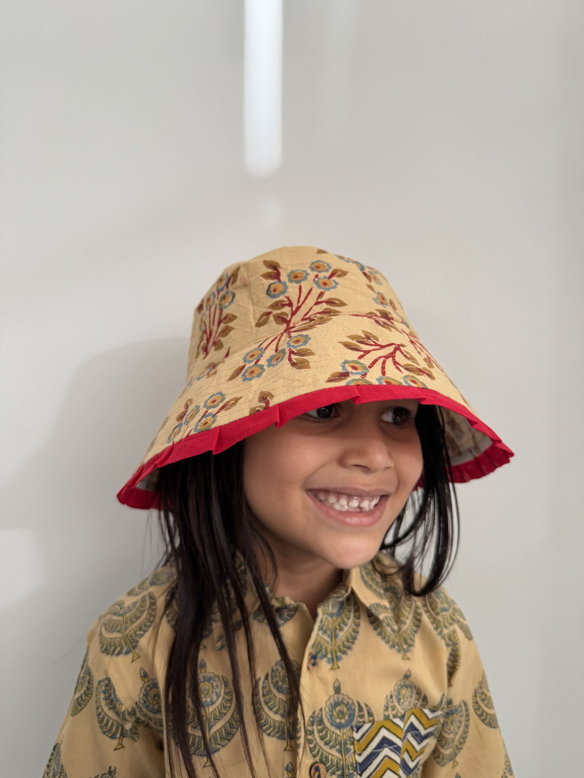 Person wearing a patterned hat and coat on a white background