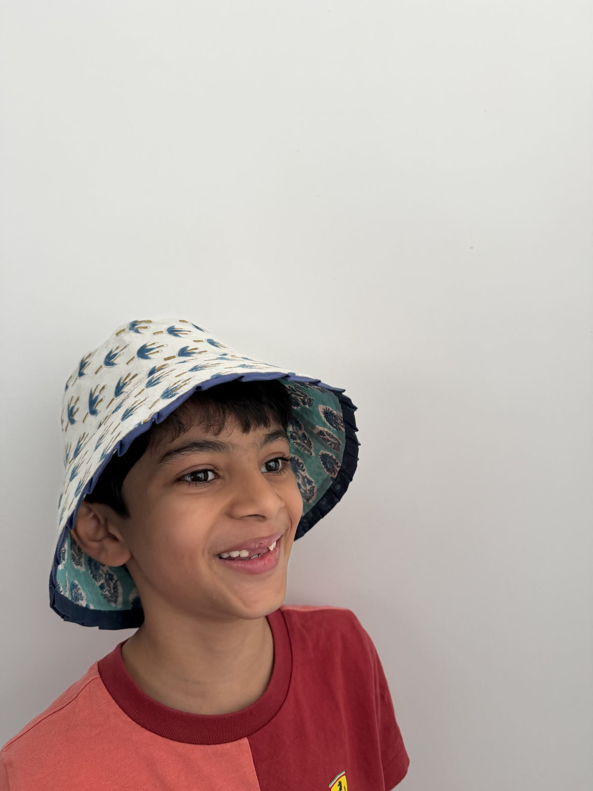 Person wearing a colorful bucket hat on a plain background