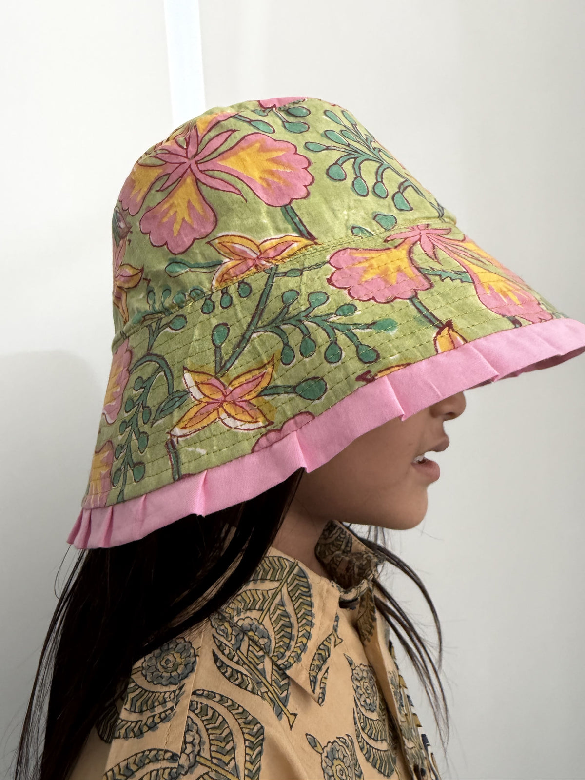 Floral-patterned headscarf with pink trim on a plain background