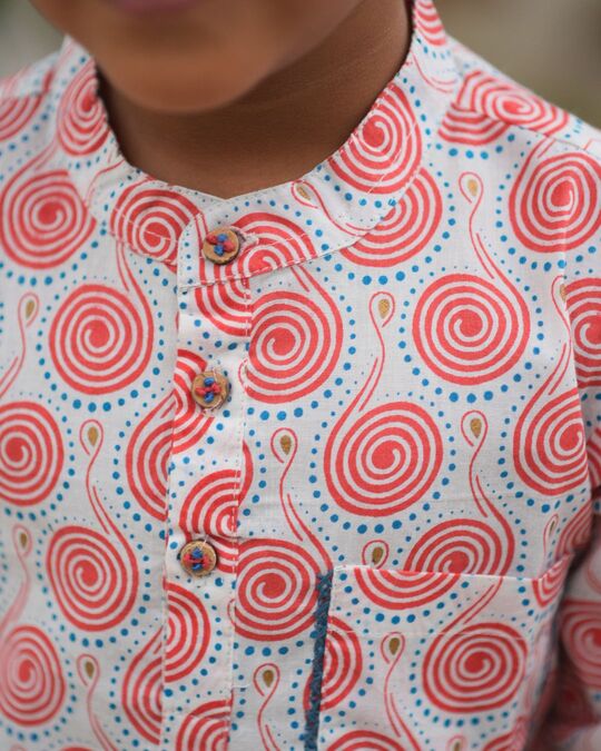 Close-up of a garment with red spiral pattern on a white background